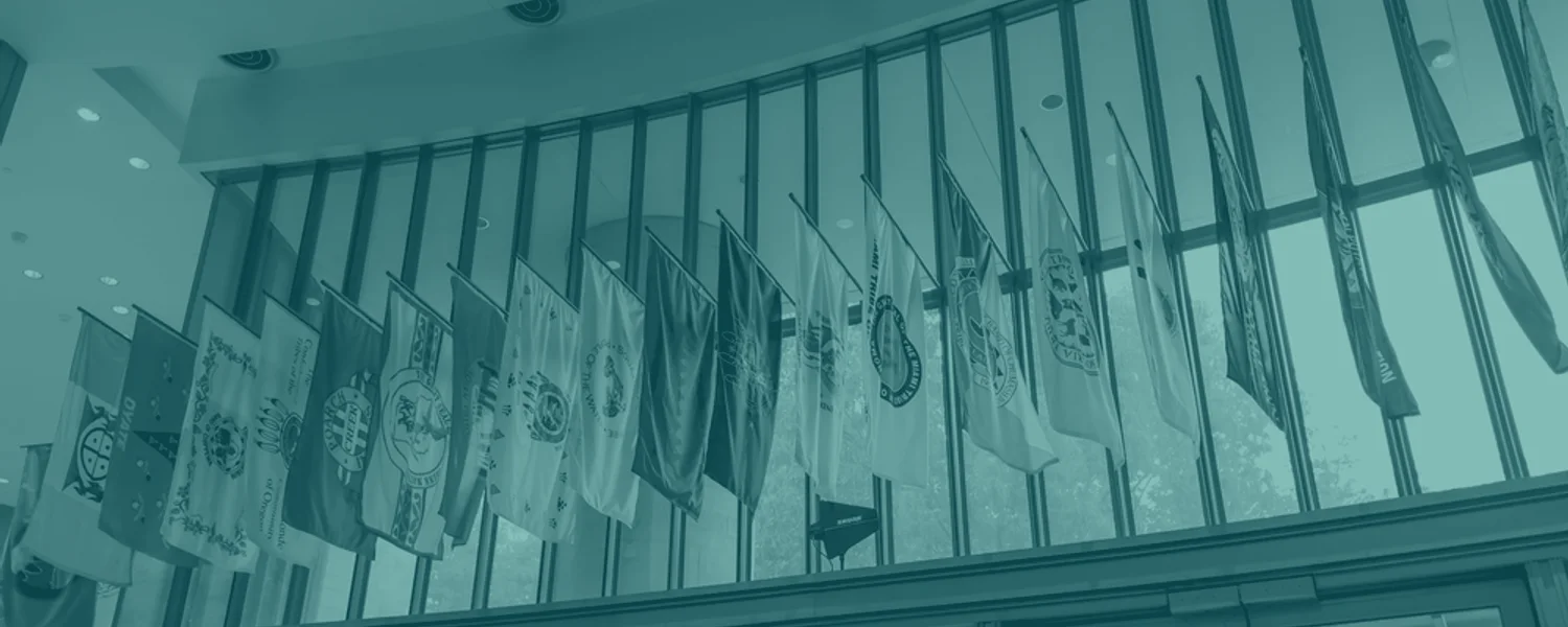 Rows of Tribal Nation flags displayed in a contemporary civic interior.